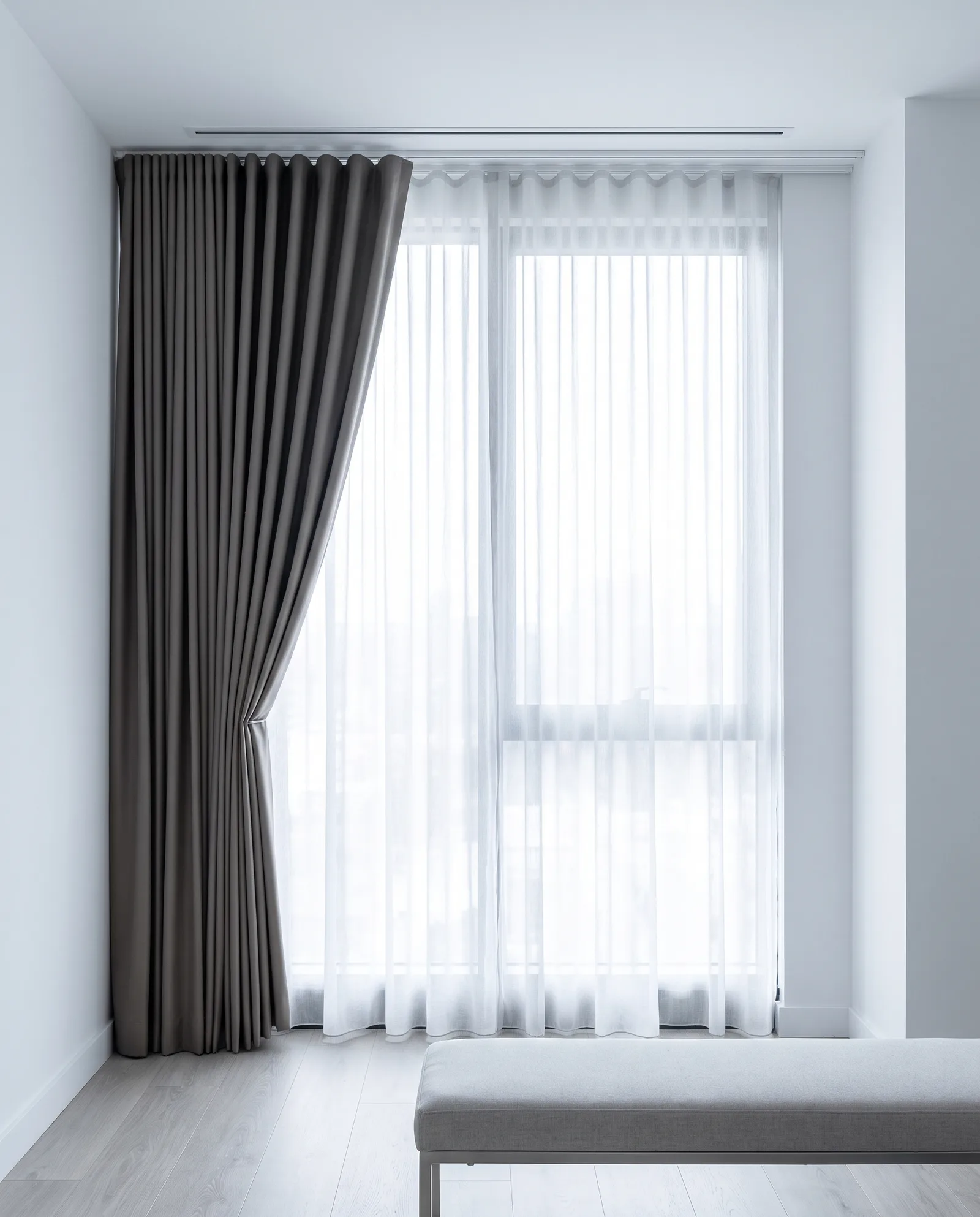 Double-layer blackout and sheer curtains on a twin ceiling track